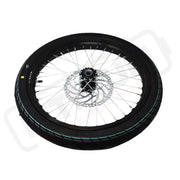 Motorcycle wheel with black tire and silver rim on a white background